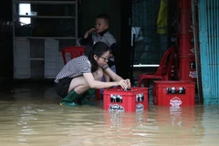 Người dân thành phố Huế dọn dẹp đồ đạc, tài sản khi nước rút dần. (Ảnh: Mai Trang/TTXVN)