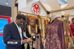 Gian hàng giới thiệu sản phẩm may mặc với công nghệ in sử dụng chất liệu thiên nhiên (ecoprint) được nhiều khách nước ngoài quan tâm. (Ảnh: Đỗ Quyên/TTXVN)