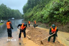 Bộ đội biên phòng thành phố Huế đào xúc đất đá, san gạt mặt đường bị sạt lở đất tại đèo Pê Kê, xã A Lưới 1. (Ảnh: Mai Trang/TTXVN)