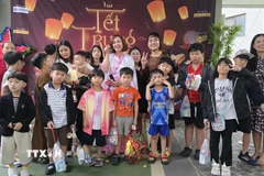 Ban tổ chức chụp ảnh kỷ niệm với các cháu thiếu nhi. (Ảnh: Đức Thắng/TTXVN)