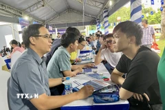 Thí sinh tìm hiểu thông tin tuyển sinh tại gian hàng của các trường. (Ảnh: Thu Hoài/TTXVN)