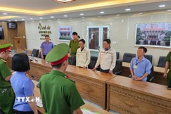 Lực lượng Công an đọc quyết định khởi tố vụ án, khởi tố bị can. (Ảnh: TTXVN phát)