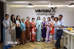 Phu nhân Hồ Thị Thu Trang (áo dài xanh ngọc) chụp ảnh lưu niệm cùng bà con kiều bào tại chương trình. (Ảnh: Đỗ Sinh/TTXVN)