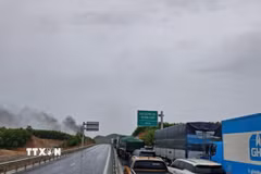 Hàng loạt phương tiện nối đuôi nhau chờ lưu thông đoạn qua khu vực cháy xe ôtô tải trên tuyến cao tốc Vạn Ninh-Cam Lộ. (Ảnh: TTXVN phát)