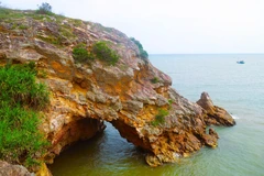 Nhìn từ trên cao, khu vực hang Mũi Trâu như một khuôn mặt người đang nhìn ra biển, cửa hang ngập trong nước khi thủy triều dâng cao. (Ảnh: Xuân Tiến/TTXVN)