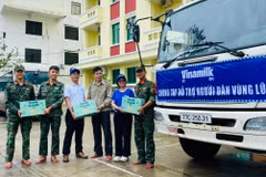 Anh Nguyễn Xuân Bình – Giám đốc Nhà máy Sữa Vinamilk Bình Định cùng cán bộ công nhân viên công ty trao tặng sản phẩm dinh dưỡng Vinamilk. (Ảnh: Vi Nam)
