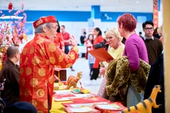 Khách mời tham quan gian hàng viết câu đối trong khuôn khổ chương trình Tết cộng đồng Xuân Bính Ngọ 2026. (Ảnh: TTXVN phát)