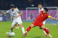 Đình Bắc số 7 U23 Việt Nam nỗ lực đi bóng trước cầu thủ U23 UAE. (Ảnh: Nguồn AFC/TTXVN phát)