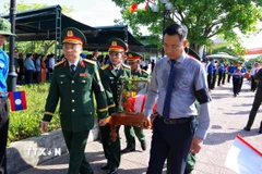 Bí thư Tỉnh ủy Quảng Bình Lê Ngọc Quang (phải) tham gia lễ an táng hài cốt liệt sỹ. (Ảnh: Tá Chuyên/TTXVN)