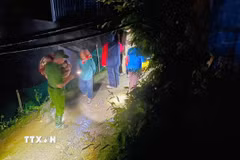 Lực lượng công an hỗ trợ người dân thôn Páo Tủng, xã Mường Khương di dời khỏi khu vực có nguy cơ sạt lở trong đêm 22/7. (Ảnh: TTXVN phát)