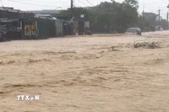 Mưa lớn khiến cho tuyến đường tại phường Vũng Áng ngập, nước chảy xiết. (Ảnh: TTXVN phát)