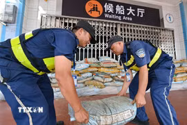 Nhân viên đặt các bao cát bên ngoài nhà chờ ở cảng Xiuying thuộc Hải Khẩu, tỉnh Hải Nam, Trung Quốc phòng chống bão Matmo. (Ảnh: THX/TTXVN)