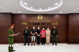 Cơ quan Cảnh sát điều tra tống đạt Quyết định khởi tố bị can đối với các đối tượng. (Ảnh: TTXVN phát)