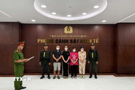 Cơ quan Cảnh sát điều tra tống đạt Quyết định khởi tố bị can đối với các đối tượng. (Ảnh: TTXVN phát)