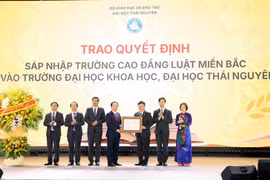 Phó Thủ tướng Lê Tiến Châu trao Quyết định của Thủ tướng Chính phủ về việc sáp nhập Trường Cao đẳng Luật miền Bắc vào Trường Đại học Khoa học - Đại học Thái Nguyên. (Ảnh: Trần Trang/TTXVN)