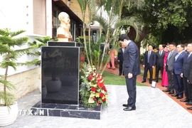 Chủ tịch nước Lương Cường và Phu nhân cùng các đại biểu đặt hoa tưởng niệm trước tượng Bác Hồ trong khuôn viên Đại sứ quán Việt Nam tại Angola. (Ảnh: Lâm Khánh/TTXVN)
