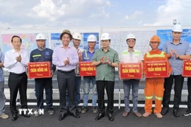 Phó Thủ tướng Trần Hồng Hà tặng quà cho công nhân thi công cầu Rạch Miễu 2. (Ảnh: Huỳnh Phúc Hậu/TTXVN)