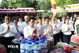 Đô trưởng Phnom Penh Khuong Sreng (bên trái, hàng đầu) cùng các đại biểu thực hiện nghi thức dâng hương tưởng niệm các nạn nhân dưới chế độ Khmer Đỏ diệt chủng. (Ảnh: AKP/TTXVN phát)