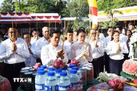 Đô trưởng Phnom Penh Khuong Sreng (bên trái, hàng đầu) cùng các đại biểu thực hiện nghi thức dâng hương tưởng niệm các nạn nhân dưới chế độ Khmer Đỏ diệt chủng. (Ảnh: AKP/TTXVN phát)