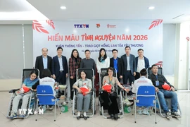 Bà Đỗ Thị Trang, Phó Bí thư chuyên trách Đảng ủy TTXVN và Phó Giáo sư, Tiến sỹ Nguyễn Hà Thanh, Viện trưởng Viện Huyết học - Truyền máu Trung ương chụp ảnh lưu niệm cùng người hiến máu tình nguyện. (Ảnh: Lê Đông/TTXVN)