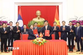 Trưởng Ban Tổ chức Trung ương Nguyễn Duy Ngọc và Trưởng Ban Tổ chức Trung ương Đảng Nhân dân Cách mạng Lào Sisay Leudetmounsone trao Thỏa thuận hợp tác giữa hai cơ quan. (Ảnh: Phương Hoa/TTXVN)