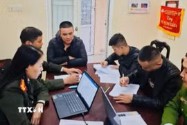 Cán bộ công an lấy lời khai các đối tượng xuất nhập cảnh trái phép sang Campuchia làm việc trong các sòng bạc trực tuyến lừa đảo trái phép. (Ảnh TTXVN phát)