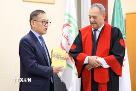 Đại sứ Việt Nam tại Algeria trao tặng Hiệu trưởng Trường Đại học Skikda cuốn sách về văn hóa Việt Nam. (Ảnh: Mạnh Hùng/TTXVN)