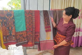 Chị Neáng Chanh Ty, Chủ nhiệm Hợp tác xã dệt thổ cẩm Khmer Văn Giáo (xã An Cư, tỉnh An Giang) giới thiệu những sản phẩm độc đáo của làng nghề. (Ảnh: Công Mạo/TTXVN)