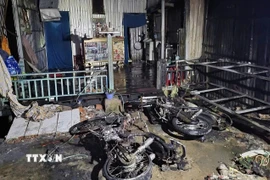 Dây điện cháy rồi bị đứt rơi xuống nhà dân gây cháy. (Ảnh: TTXVN phát)