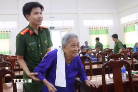 Lực lượng Công an hỗ trợ thân nhân các liệt sỹ đến lấy mẫu ADN tại Vĩnh Long. (Ảnh: Lê Thúy Hằng/TTXVN)