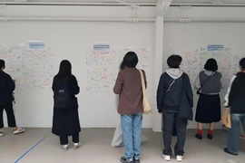 Những người tham gia chia sẻ những suy nghĩ viết tay về ý nghĩa của cuộc sống bihon đối với họ tại B-Fair, ngày 1 tháng 11. (Ảnh: Korea Times)