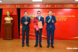 Phó Bí thư Đảng ủy Mặt trận Tổ quốc, các đoàn thể Trung ương Nguyễn Phi Long trao Quyết định và Phó Chủ tịch Thường trực Hội Nhà báo Việt Nam Nguyễn Đức Lợi tặng hoa chúc mừng đồng chí Lê Quốc Minh. (Nguồn: congluan.vn)