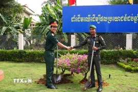 Sỹ quan trẻ 2 nước trồng cây hữu nghị thanh niên tại Đồn Biên phòng Cửa khẩu quốc tế Mộc Bài. (Ảnh: Minh Phú/TTXVN)