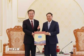 Bí thư Tỉnh ủy Lai Châu Lê Minh Ngân (bên phải) tặng sản phẩm Hồng trà của tỉnh Lai Châu cho Bí thư Tỉnh ủy Vân Nam Trung Quốc Vương Ninh. (Ảnh: Quý Trung/TTXVN)