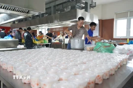 Sinh viên Trường Đại học Đông Á (thành phố Đà Nẵng) chuẩn bị và đóng gói hơn 600 suất ăn chuyển đến người dân vùng ngập sâu, chia cắt. (Ảnh: Khoa Chương/TTXVN)