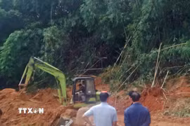 Lực lượng chức năng nỗ lực giải phóng hiện trường các điểm sạt lở để thông tuyến quốc lộ 28, đoạn qua đèo Gia Bắc (xã Sơn Điền, Lâm Đồng). (Ảnh: TTXVN phát)