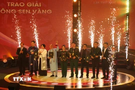 Thứ trưởng Bộ Văn hóa, Thể thao và Du lịch Tạ Quang Đông và Phó Trưởng ban Thường trực Ban Tuyên giáo và Dân vận Trung ương Lại Xuân Môn trao giải thưởng Bông sen Vàng. (Ảnh: Thu Hương/TTXVN)