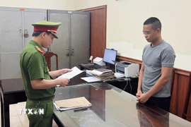 Cơ quan Cảnh sát điều tra công bố lệnh bắt tạm giam đối tượng Lê Văn Hải. (Ảnh: TTXVN phát)