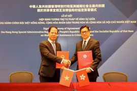 Phó Viện trưởng Viện Kiểm sát nhân dân tối cao Trần Hải Quân và Cục trưởng Cục An ninh Hong Kong Đặng Bính Cường ký kết hiệp định. (Ảnh: Xuân Vịnh/TTXVN)