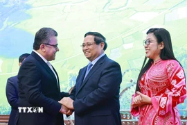 Thủ tướng Phạm Minh Chính và Phu nhân chào mừng các Đại sứ, Đại biện, Trưởng đại diện các tổ chức quốc tế tại Hà Nội cùng Phu nhân, Phu quân. (Ảnh: Dương Giang/TTXVN)
