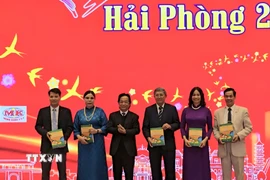 Lãnh đạo Hội Liên lạc Việt kiều tặng kiều bào sách dạy tiếng Việt cho trẻ em. (Ảnh: Minh Thu/TTXVN)