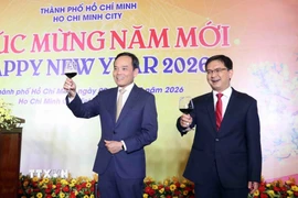 Ông Trần Lưu Quang (trái), Ủy viên Bộ Chính trị, Bí thư Thành ủy Thành phố Hồ Chí Minh mời quan khách nâng ly chúc mừng năm mới. (Ảnh: Xuân Khu/TTXVN)