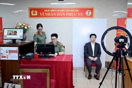 Thu nhận ảnh khuôn mặt của người nước ngoài cư trú tại Việt Nam đến làm thủ tục cấp tài khoản định danh điện tử. (Ảnh: Phạm Kiên/TTXVN)