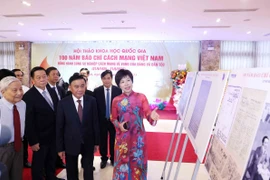 Tổng Giám đốc TTXVN Vũ Việt Trang giới thiệu trưng bày ảnh chuyên đề "100 năm Báo chí cách mạng Việt Nam" với các đại biểu dự hội thảo. (Ảnh: Phương Hoa/TTXVN)