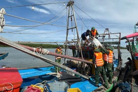 Bộ đội Biên phòng Nghệ An hỗ trợ ngư dân neo đậu tàu thuyền tại nơi tránh trú an toàn. (Ảnh: TTXVN phát)