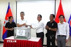 Đại diện KVA trao số tiền quyên góp ủng hộ cho lãnh đạo Đại sứ quán Việt Nam tại Campuchia. (Ảnh: Hoàng Minh/TTXVN)