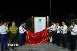 Các đại biểu tháo biểu trưng Danh lục Xanh được trưng bày trong trọng trong khuôn viên Ban quản lý Vườn quốc gia Côn Đảo. (Ảnh: Huỳnh Sơn/TTXVN)