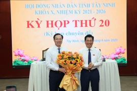 Bí thư Tỉnh ủy, Chủ tịch HĐND tỉnh Tây Ninh Nguyễn Mạnh Hùng (bên phải) tặng hoa chúc mừng tân Phó Chủ tịch UBND tỉnh Đoàn Trung Kiên. (Ảnh: Thanh Tân/TTXVN)