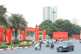 Biểu tượng búa liềm, cờ Đảng, cờ Tổ quốc chào mừng Đại hội đại biểu toàn quốc lần thứ XIV của Đảng trước cửa Trung tâm Hội nghị Quốc gia. (Ảnh: Lê Đông/TTXVN)