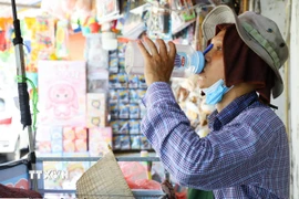 Người dân mưu sinh khi trời nắng nóng. (Ảnh: Lê Đông/TTXVN)